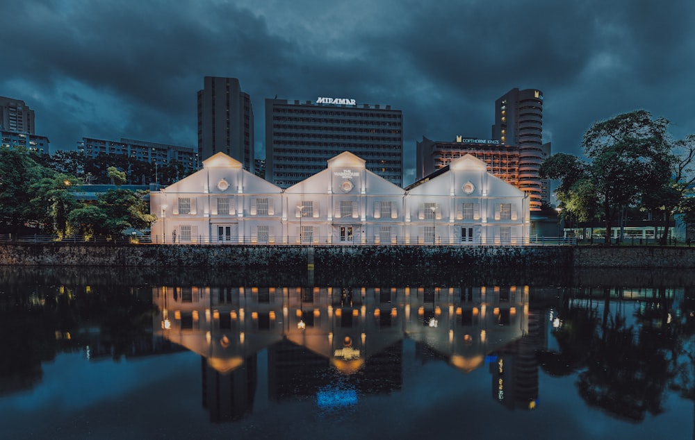 a large white building sitting next to a body of water