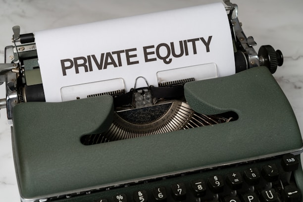 A vintage green typewriter with a sheet of paper inserted displays the text 'PRIVATE EQUITY' in bold letters. The typewriter rests on a white marble surface, and its keys and mechanisms are visible.