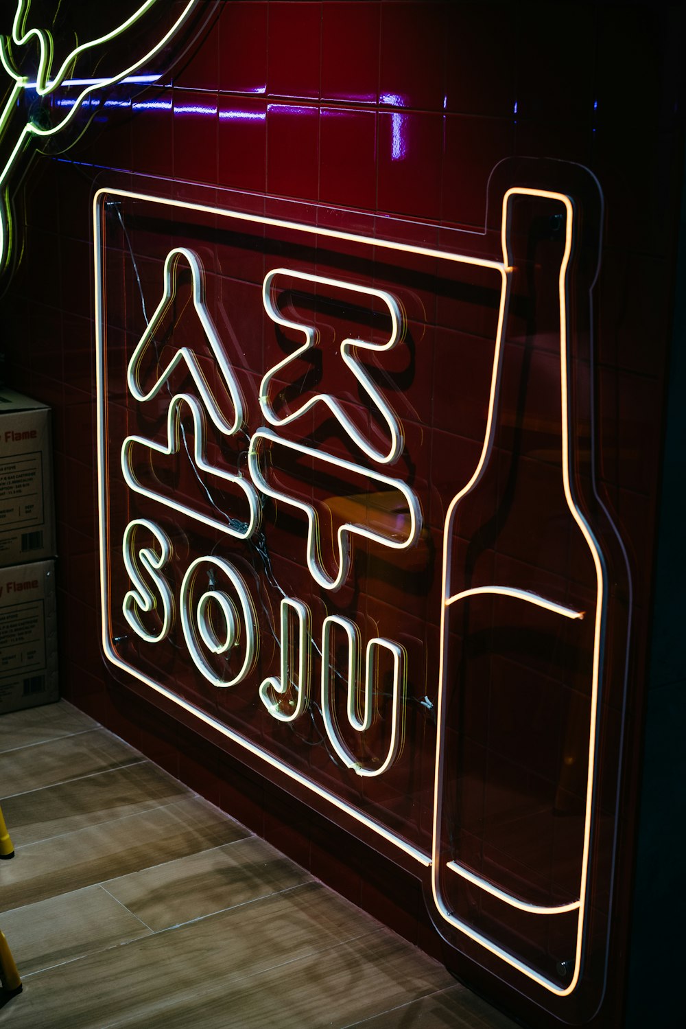 a neon sign with a bottle of wine in front of it