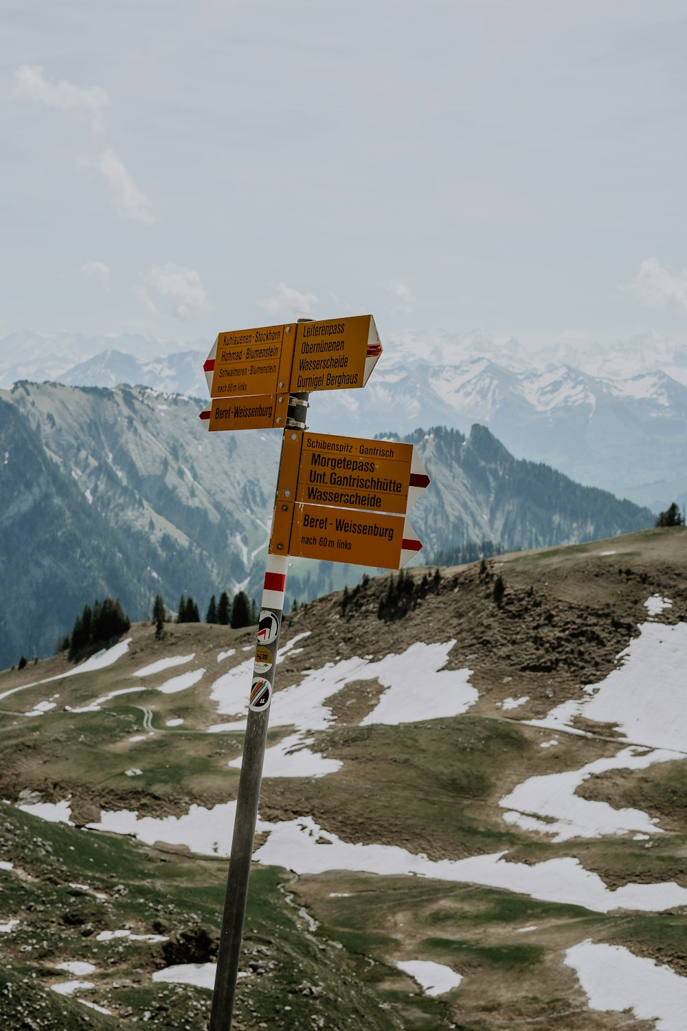 a couple of signs on top of a snow covered hill