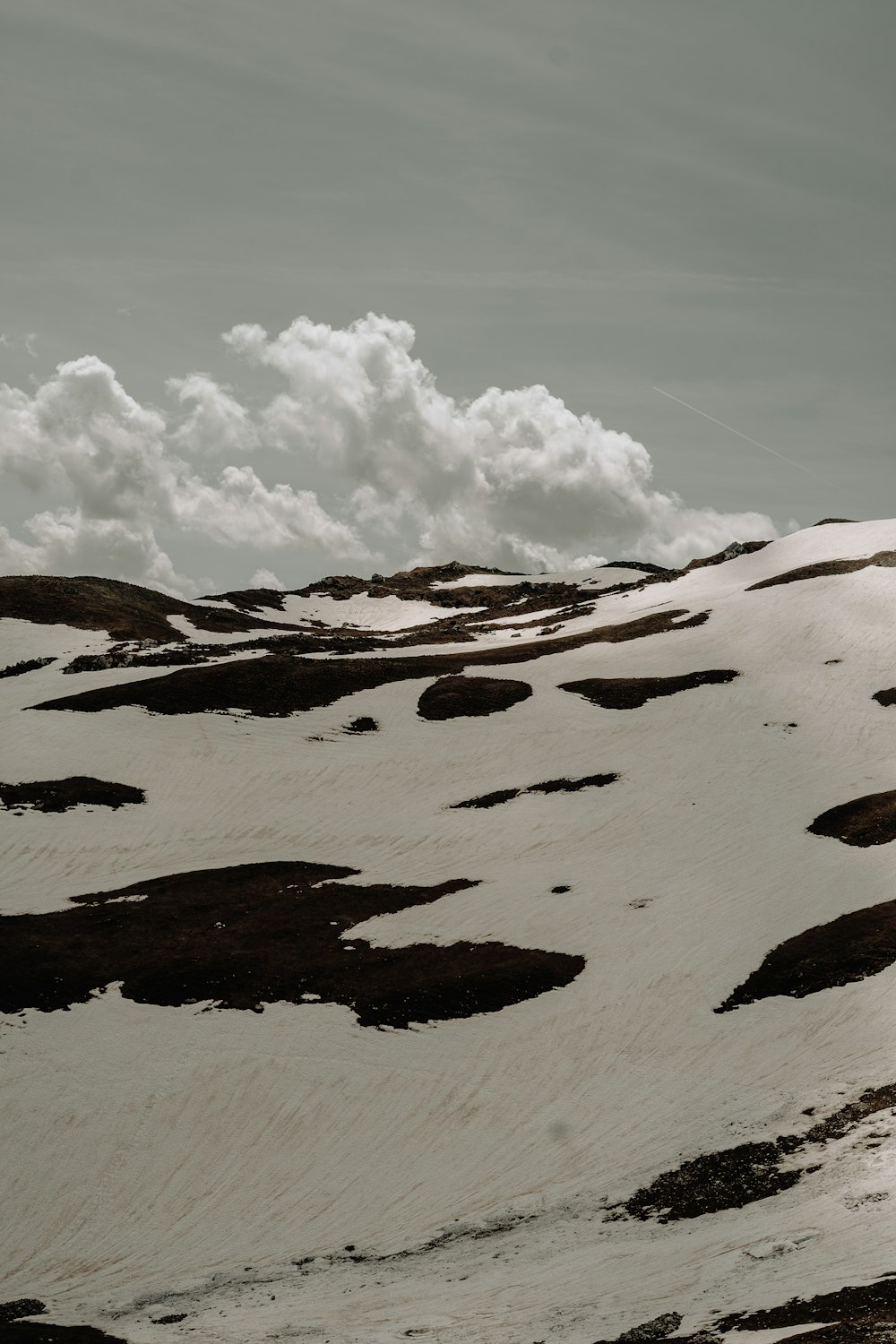 a snow covered mountain under a cloudy sky