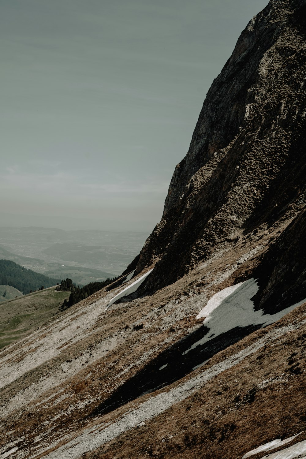 a mountain with snow on the ground and mountains in the background