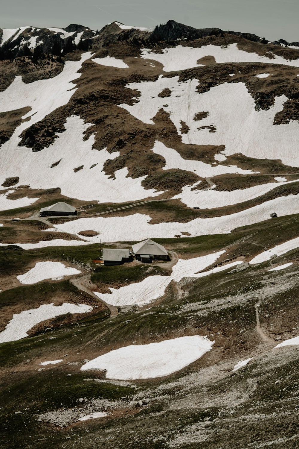 a snow covered mountain with a house on top of it