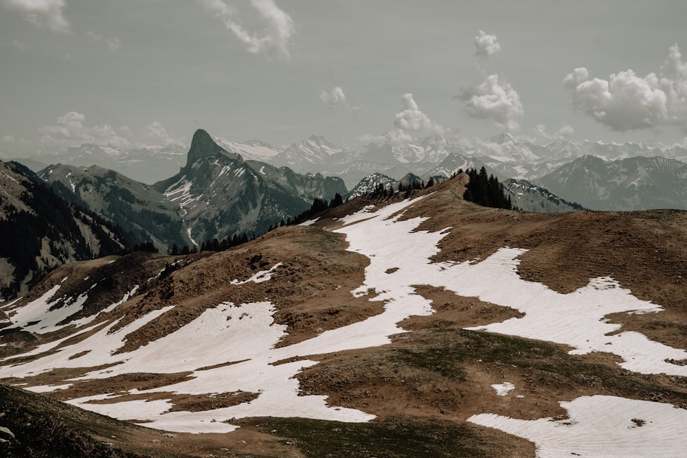 a snow covered mountain with mountains in the background