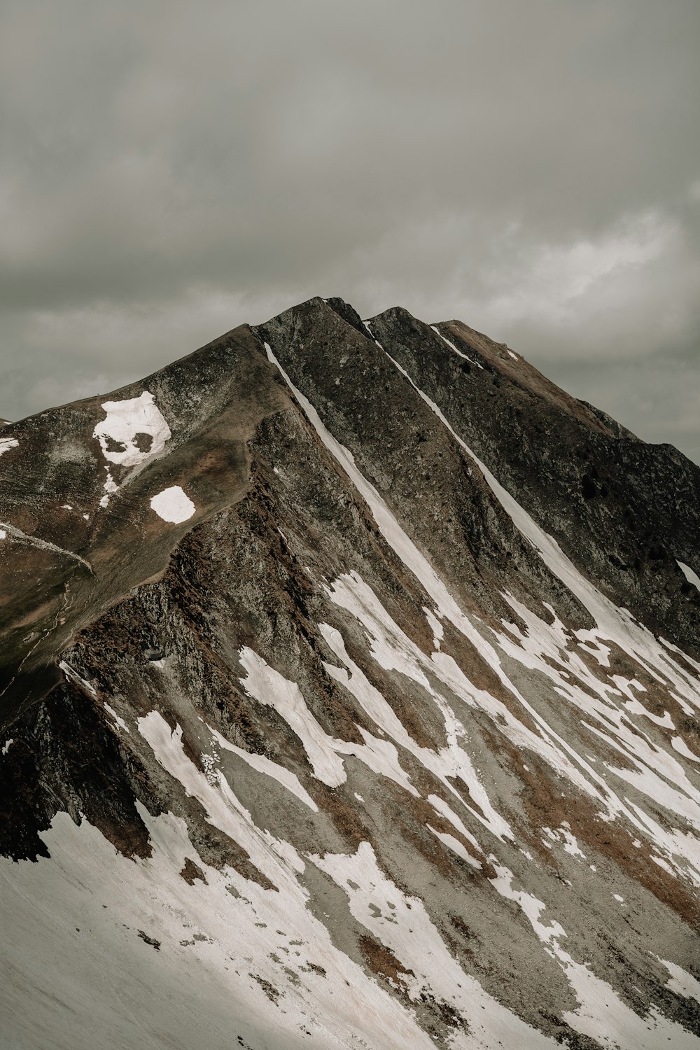 a snow covered mountain with a cloudy sky