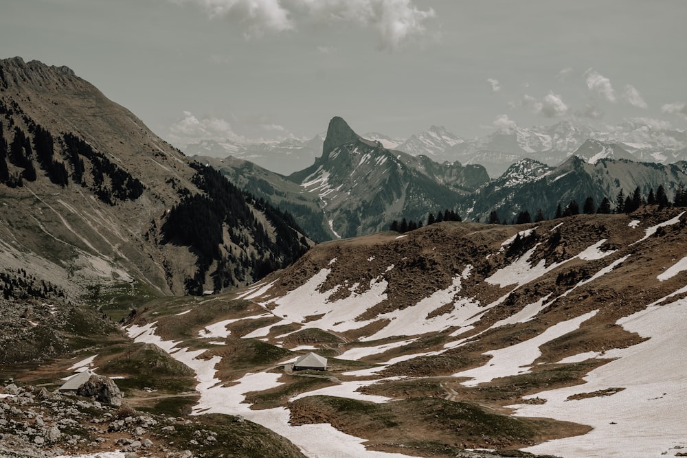 a snow covered mountain range with mountains in the background