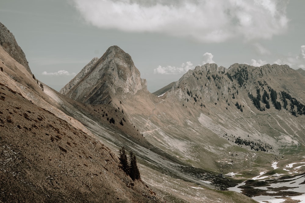 a view of a mountain range from the top of a hill