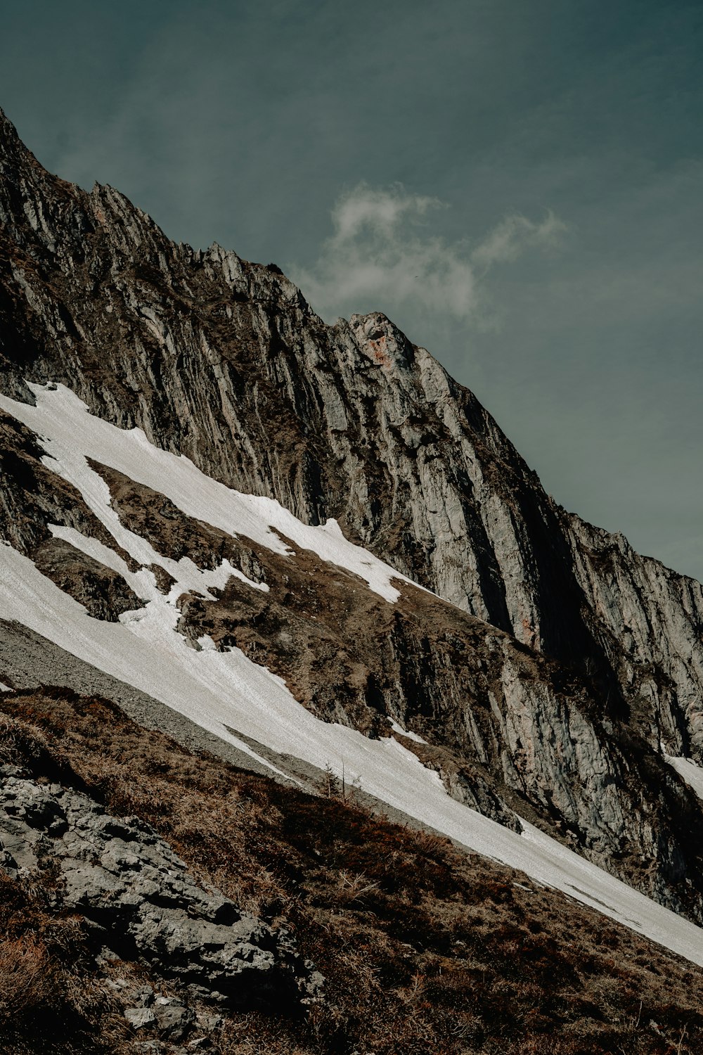 a snow covered mountain with a few clouds in the sky