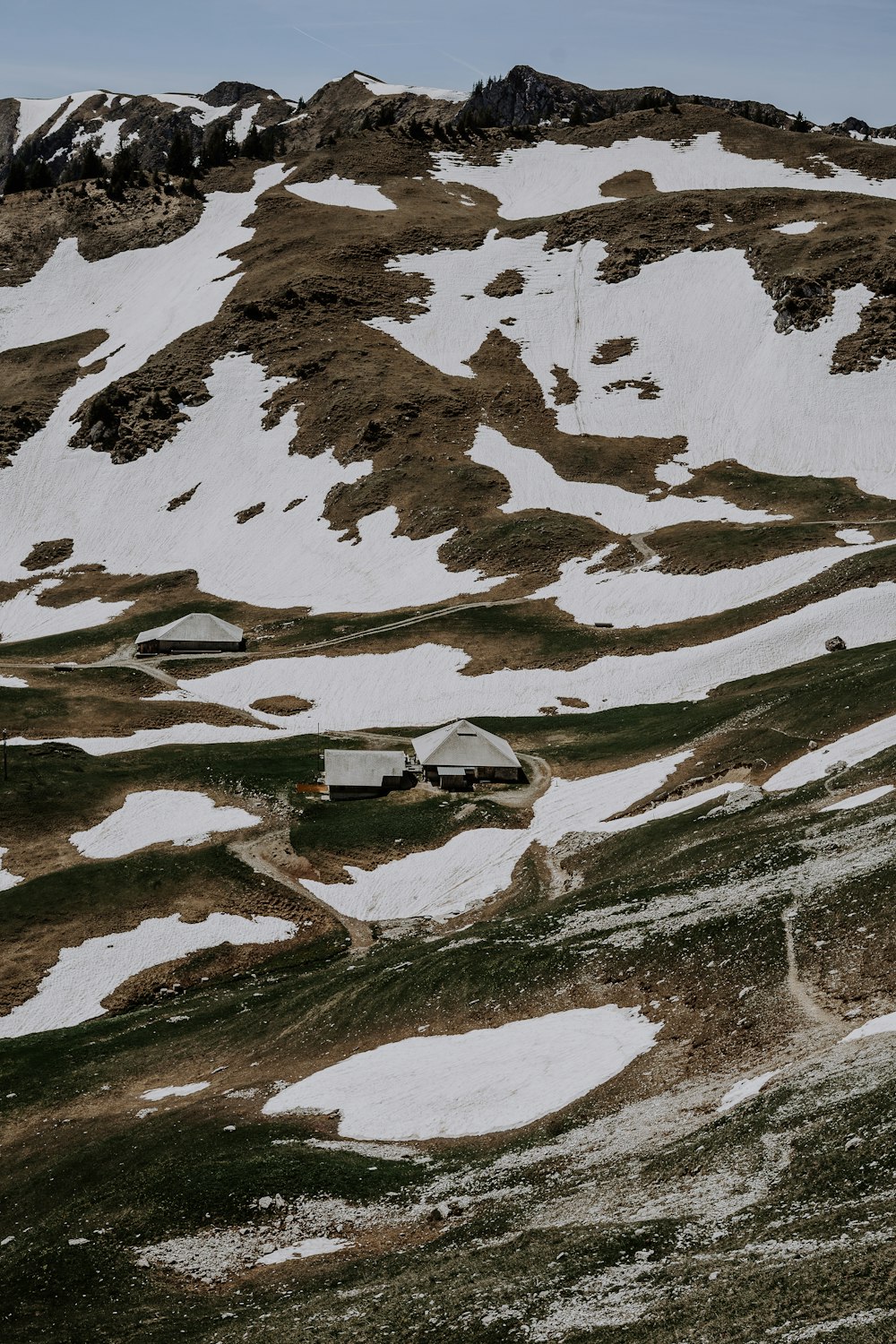 a snow covered mountain with a house in the foreground