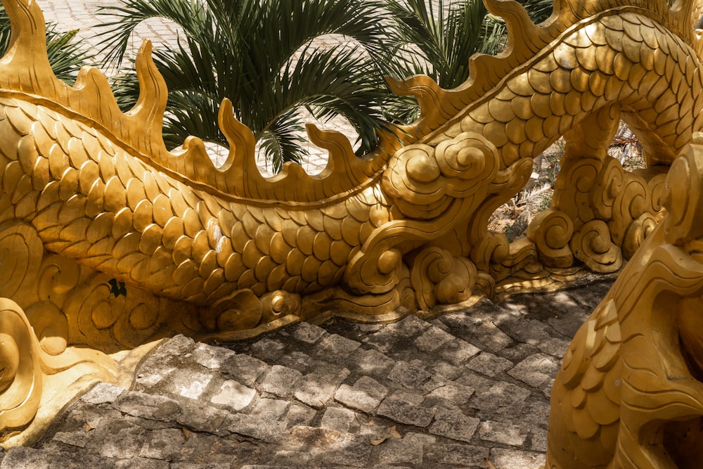 a golden dragon statue sitting on top of a stone walkway