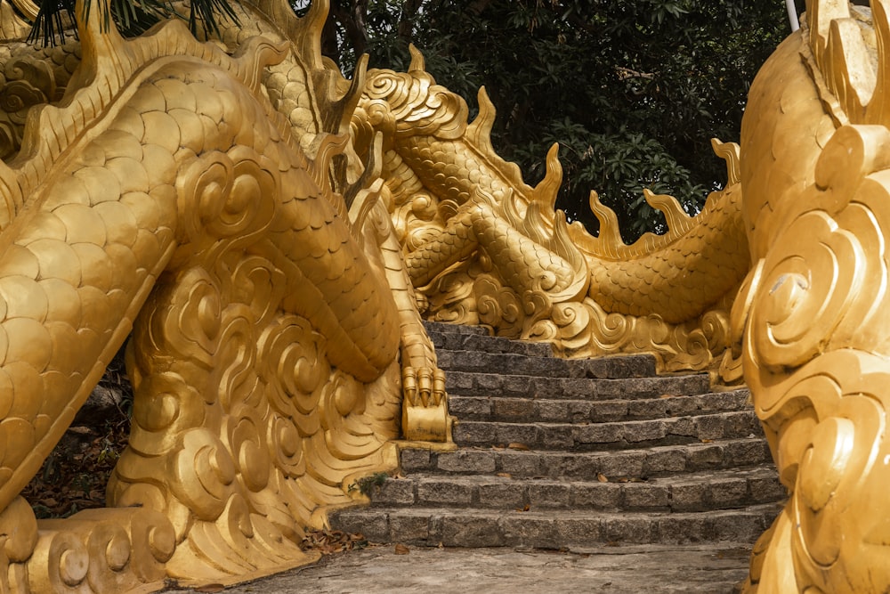 a large golden dragon statue sitting on top of a set of steps