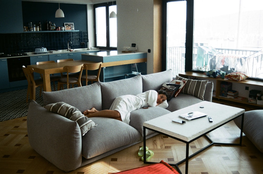 a man laying on a couch in a living room
