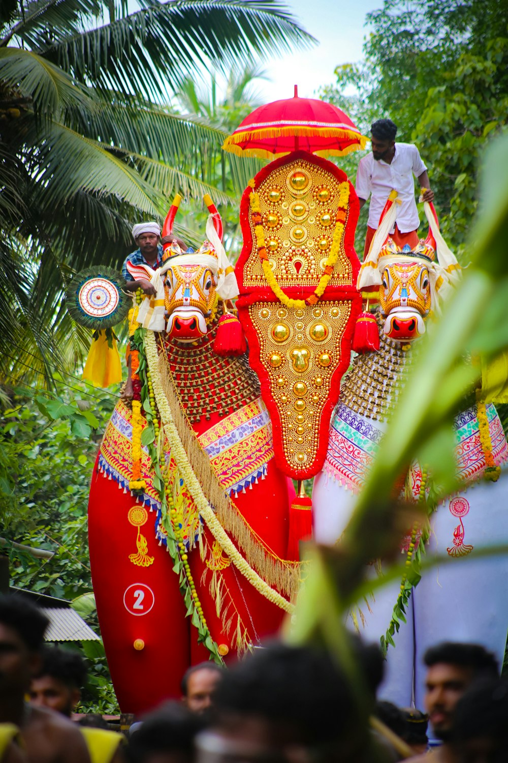 a large red and gold decorated elephant in a parade