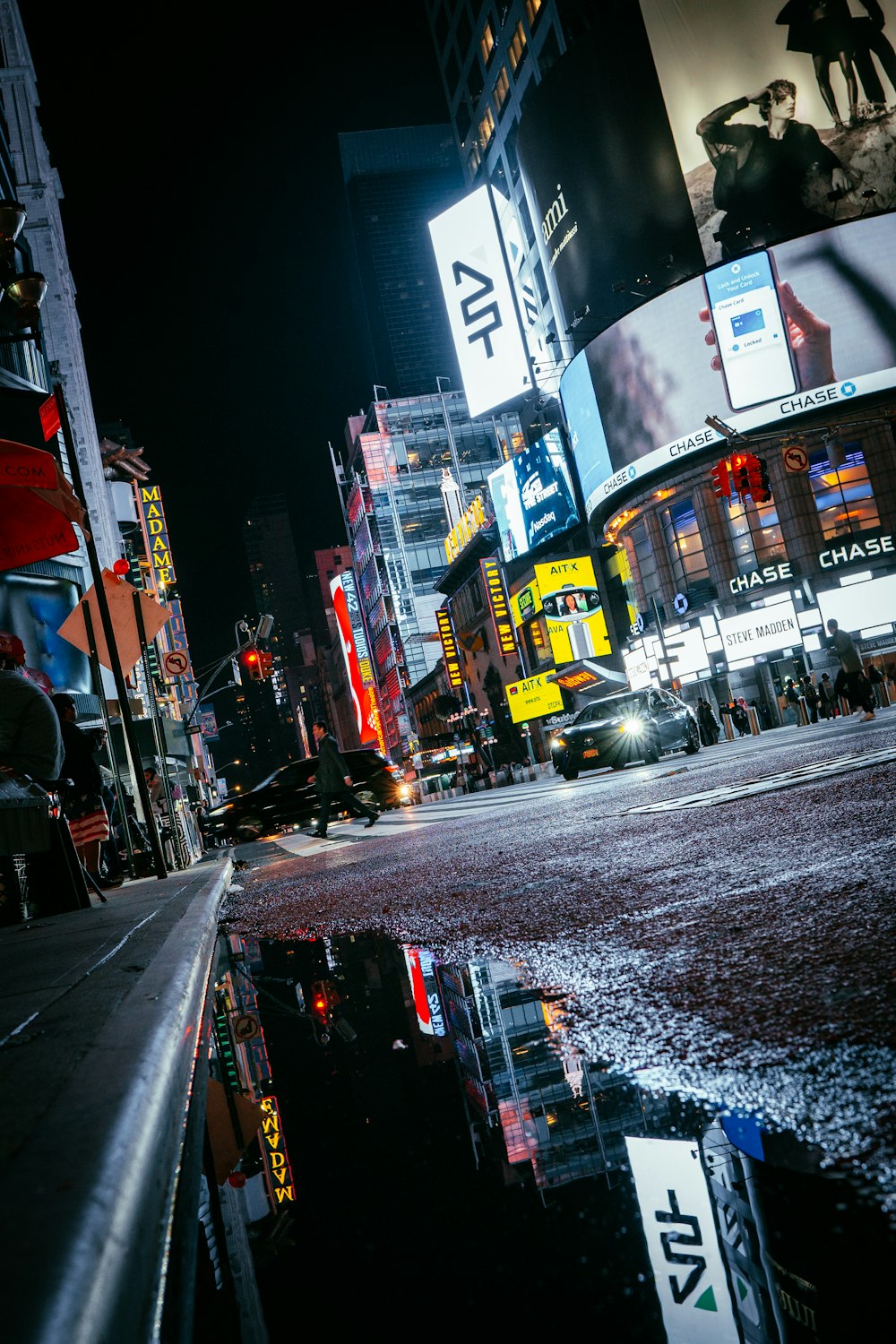 a city street at night with a puddle of water