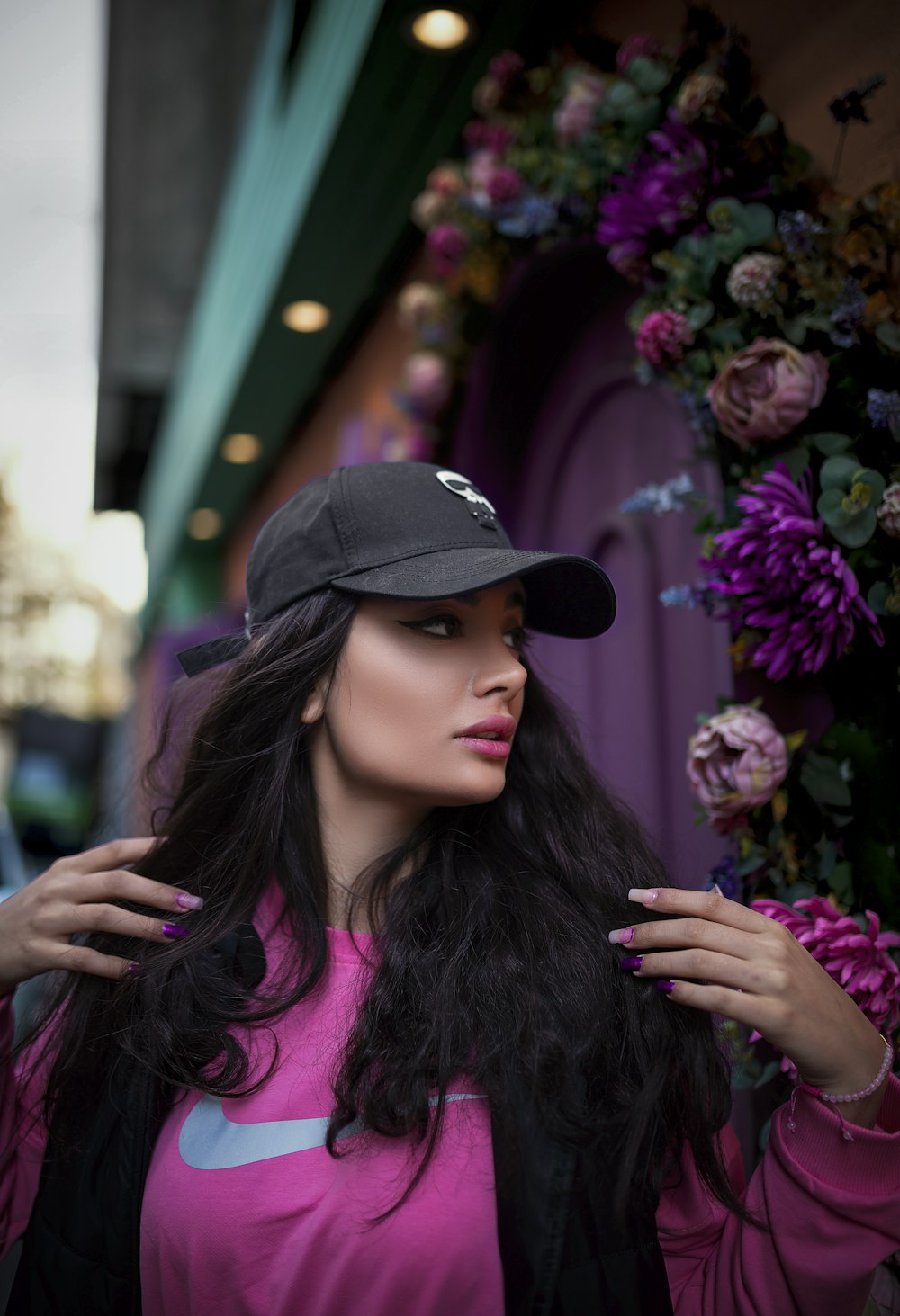 a woman in a pink shirt and black hat