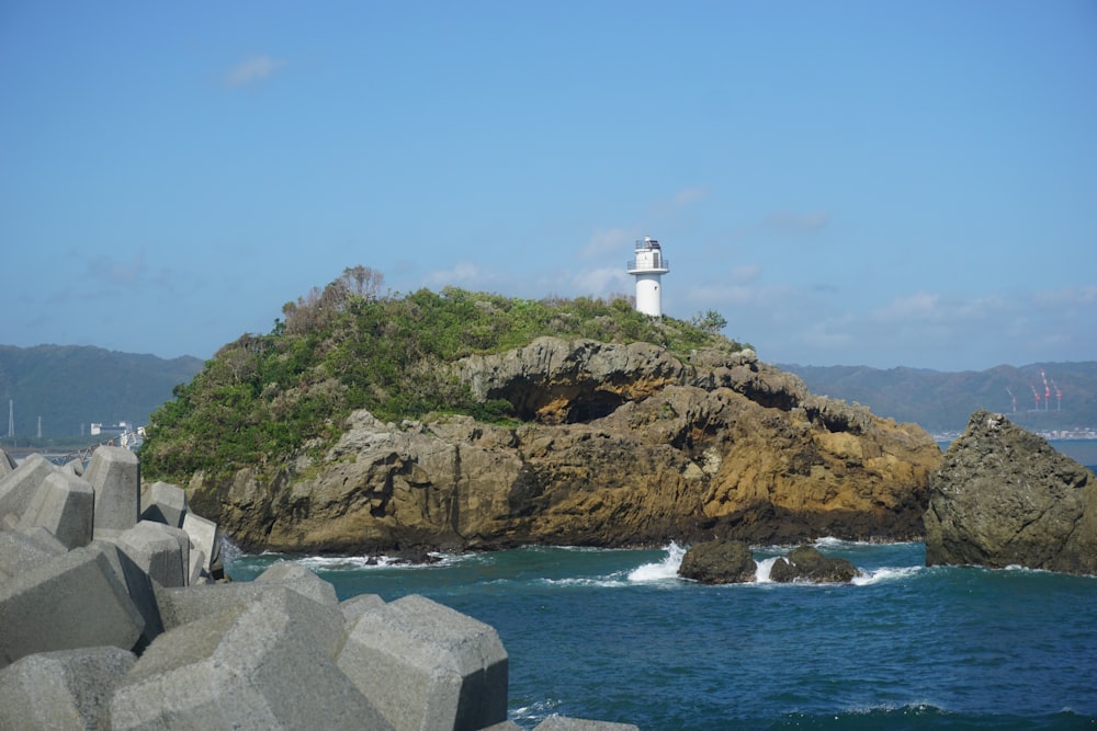 a light house on a rocky outcropping in the ocean