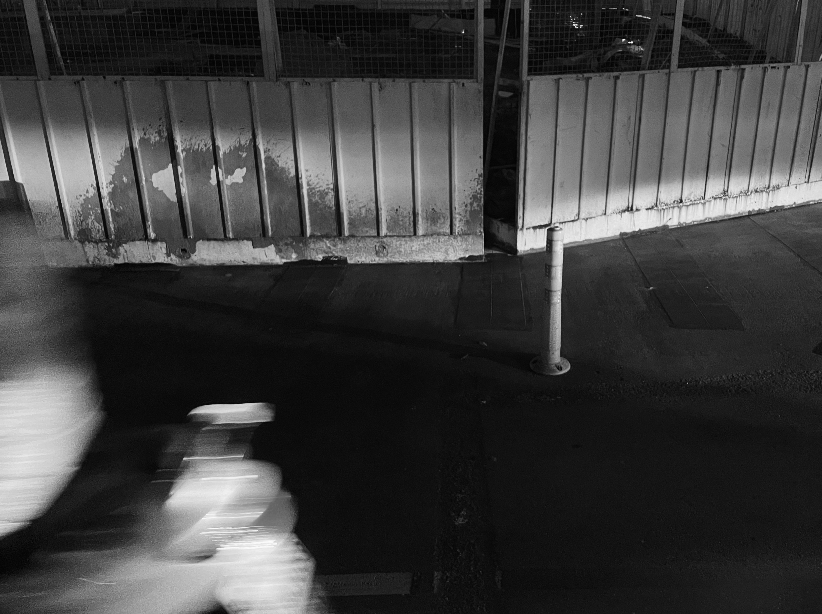 a man riding a bike down a street next to a fence