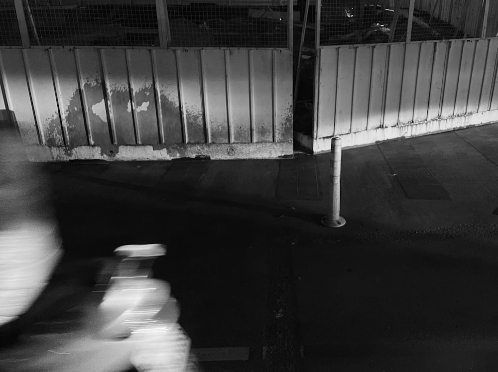 a man riding a bike down a street next to a fence