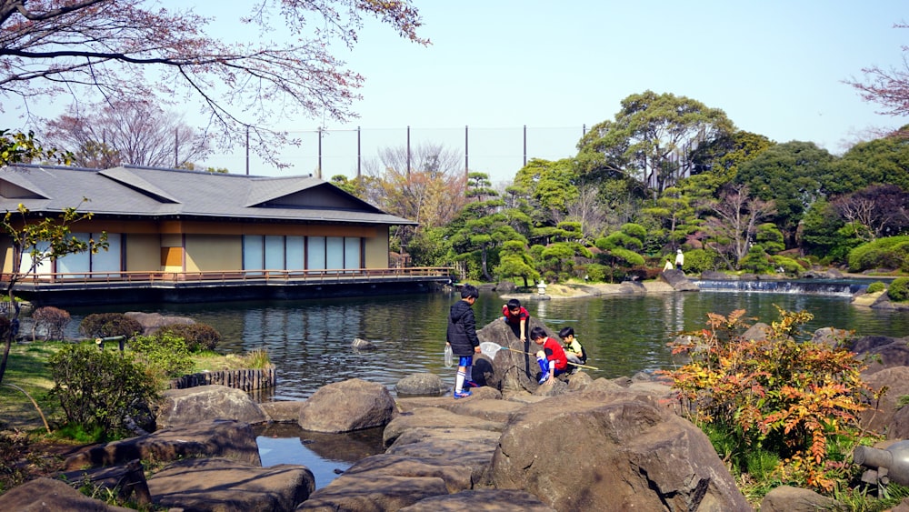 a group of people standing around a pond