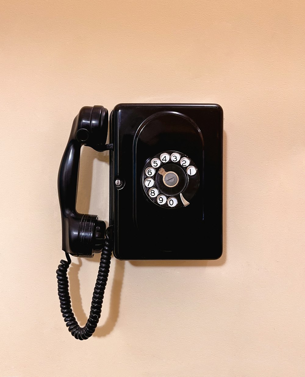 an old fashioned black telephone on a wall
