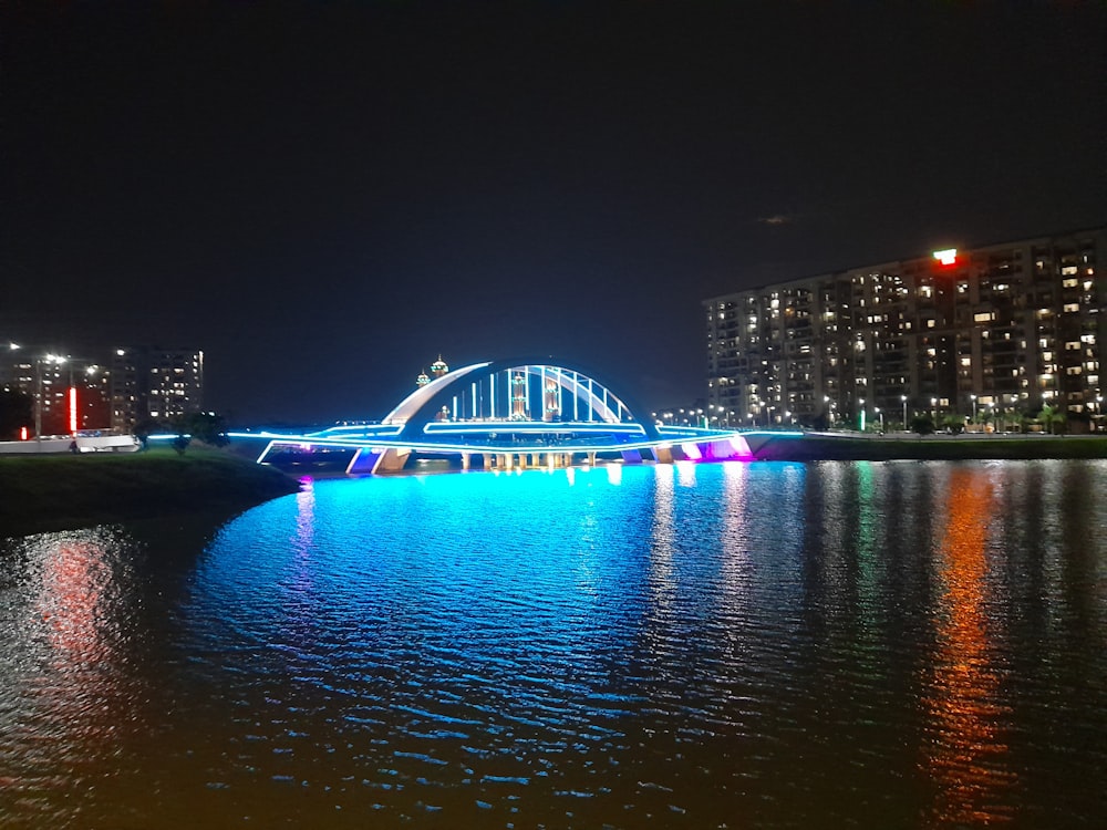 a bridge is lit up at night over a body of water