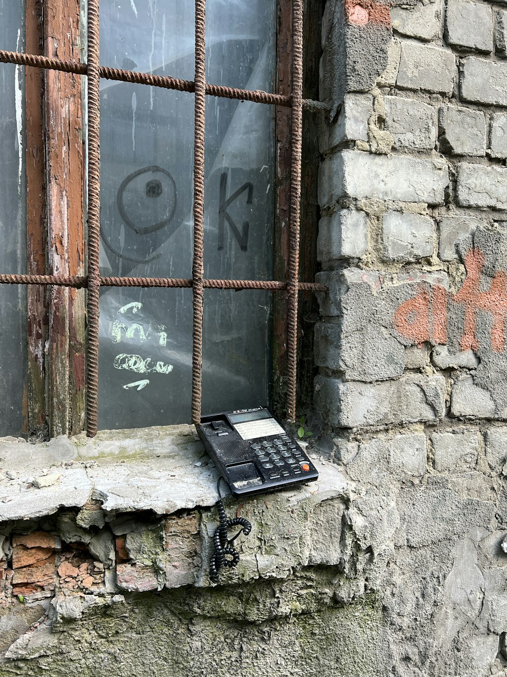 a cell phone sitting on top of a window sill