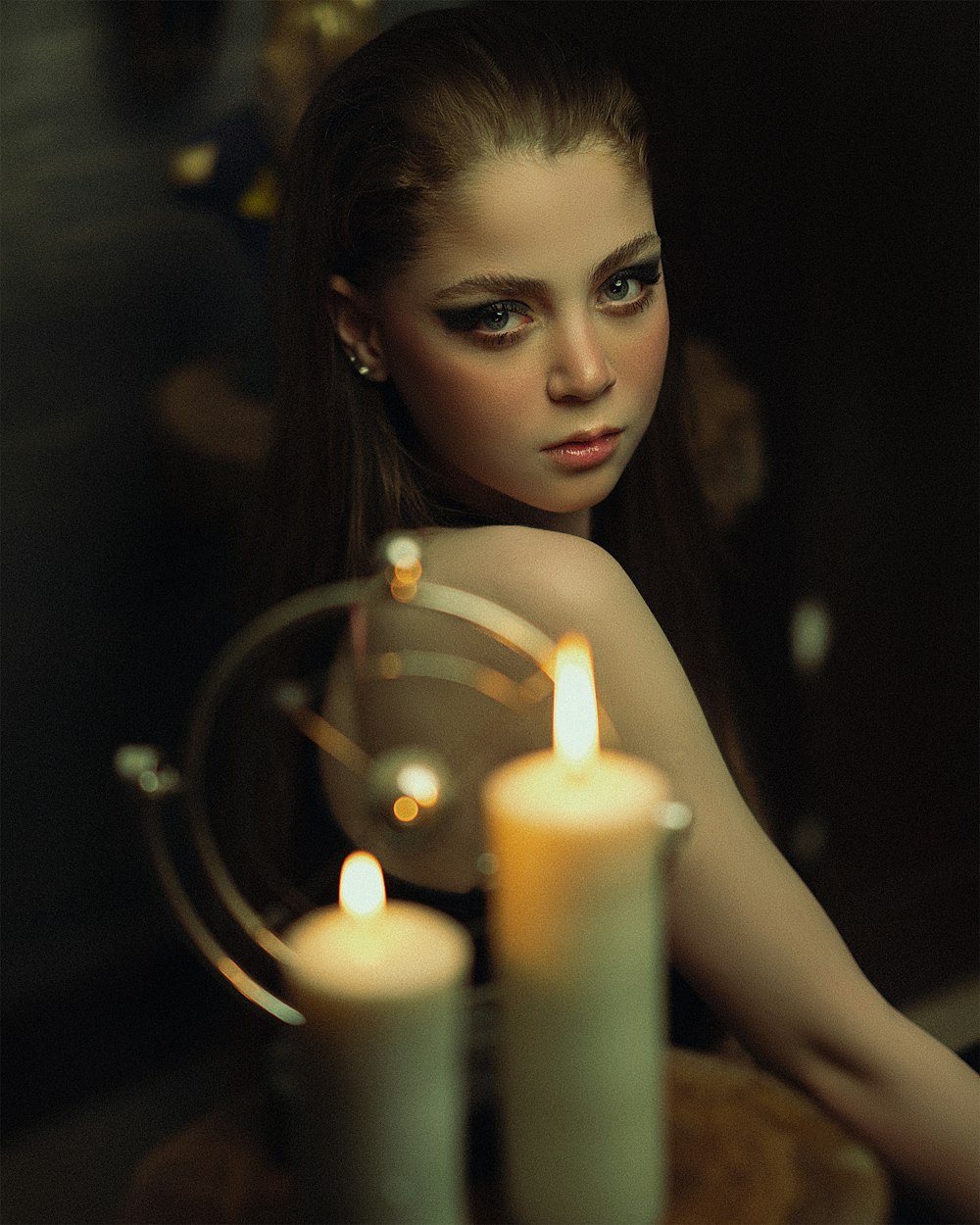 a woman sitting in front of two candles