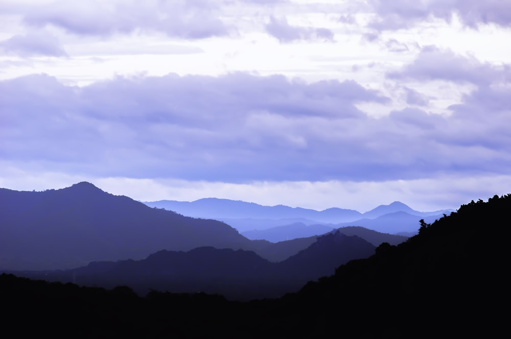 a view of a mountain range with clouds in the sky