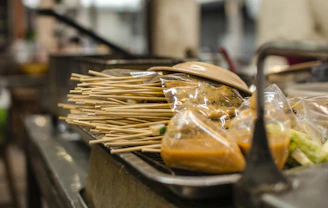 A vibrant close-up of sizzling Asian fusion skewers glazed with a rich, spicy sauce.