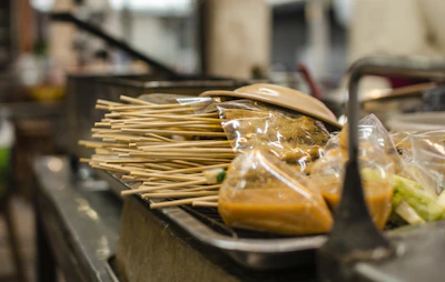 A vibrant close-up of sizzling Asian fusion skewers glazed with a rich, spicy sauce.