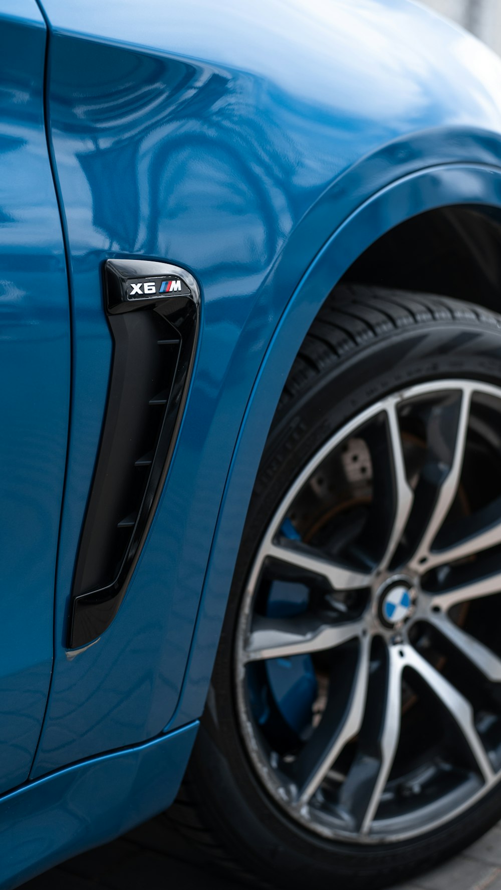 a close up of a blue car parked on a street