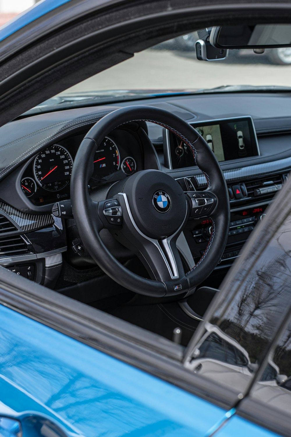 the interior of a blue car with a steering wheel
