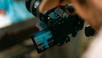 a person holding a camera with a video attached to it