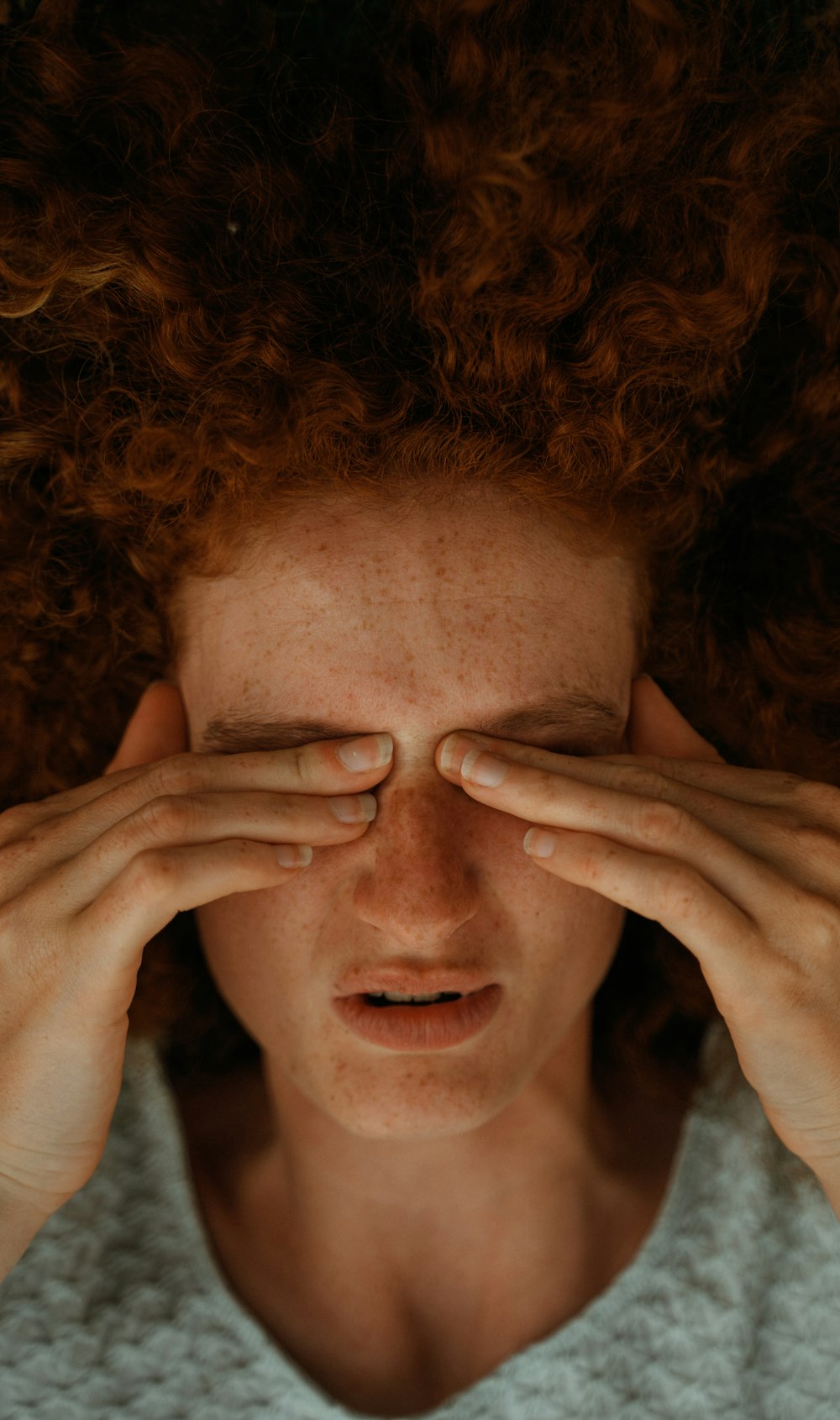 a woman with red hair covering her eyes