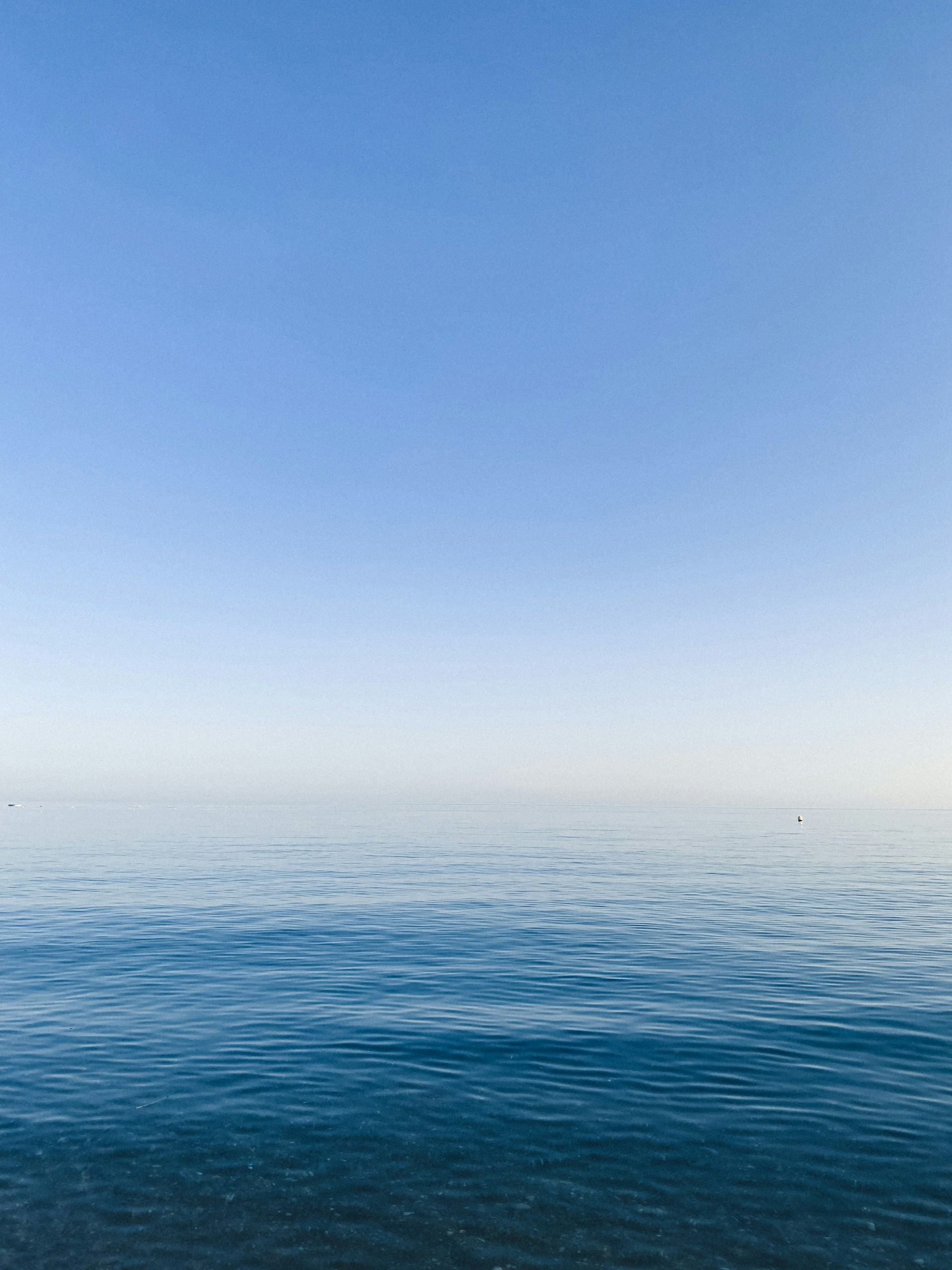 a large body of water sitting under a blue sky