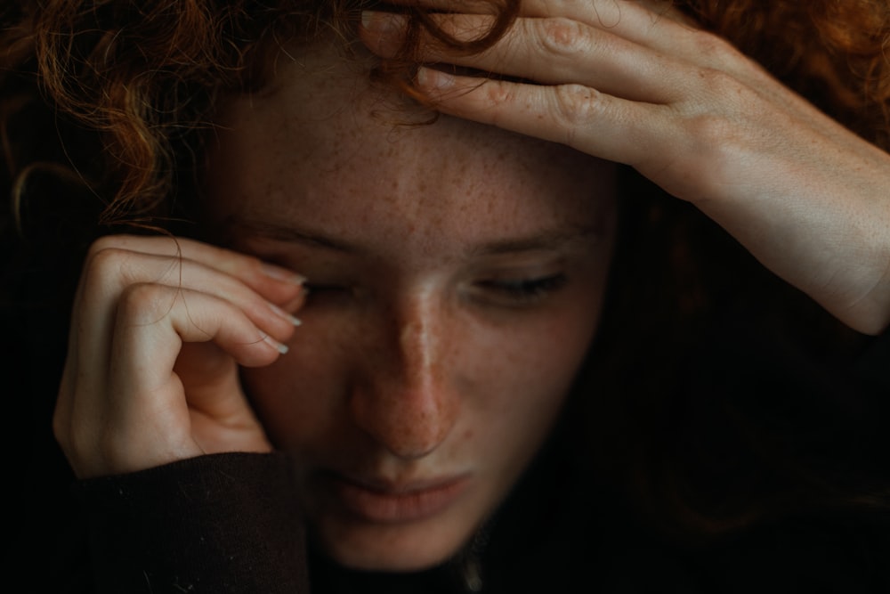 a close up of a person holding their head