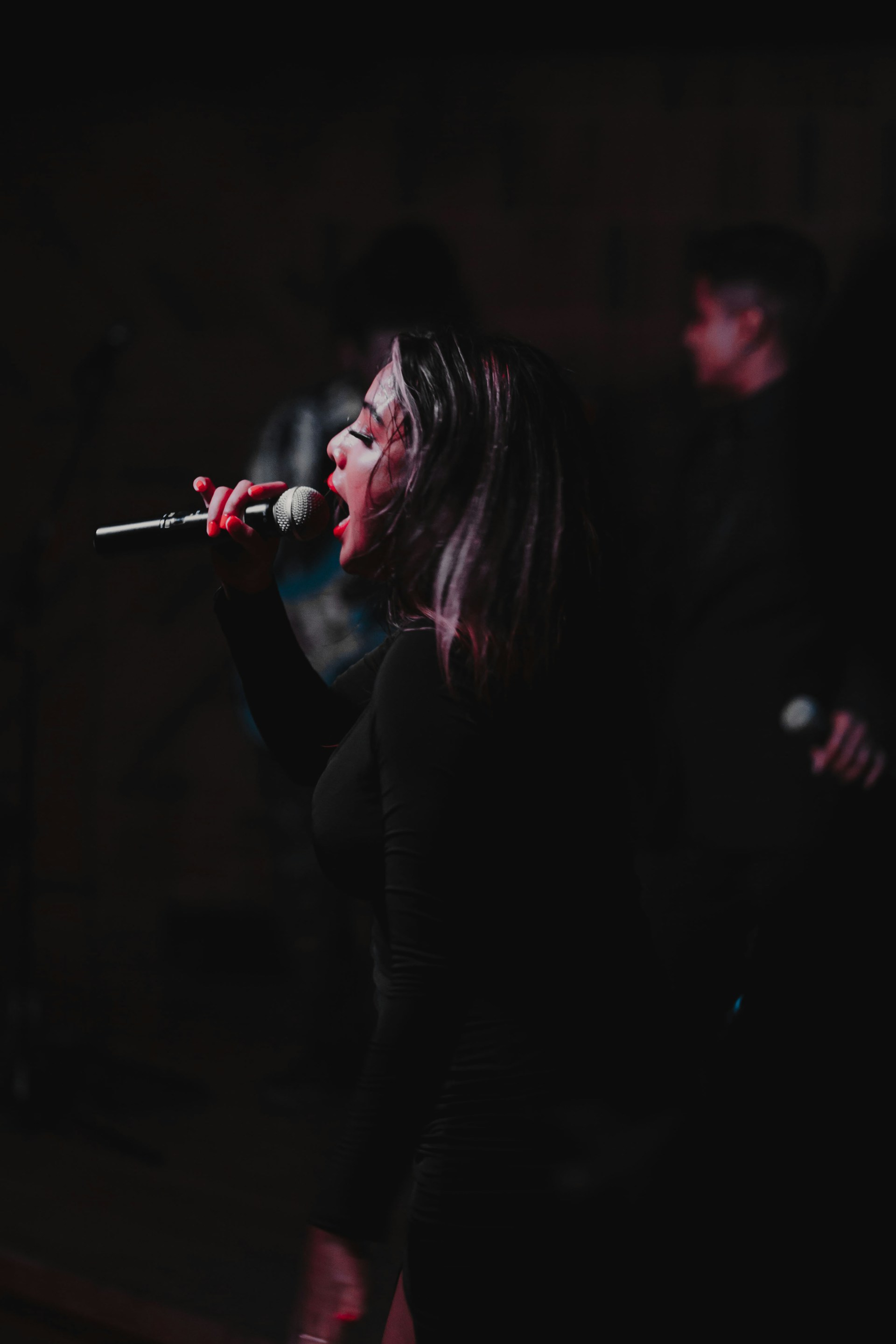 A passionate flamenco singer with expressive face, mid-performance, surrounded by dim stage lighting that highlights the emotional depth.