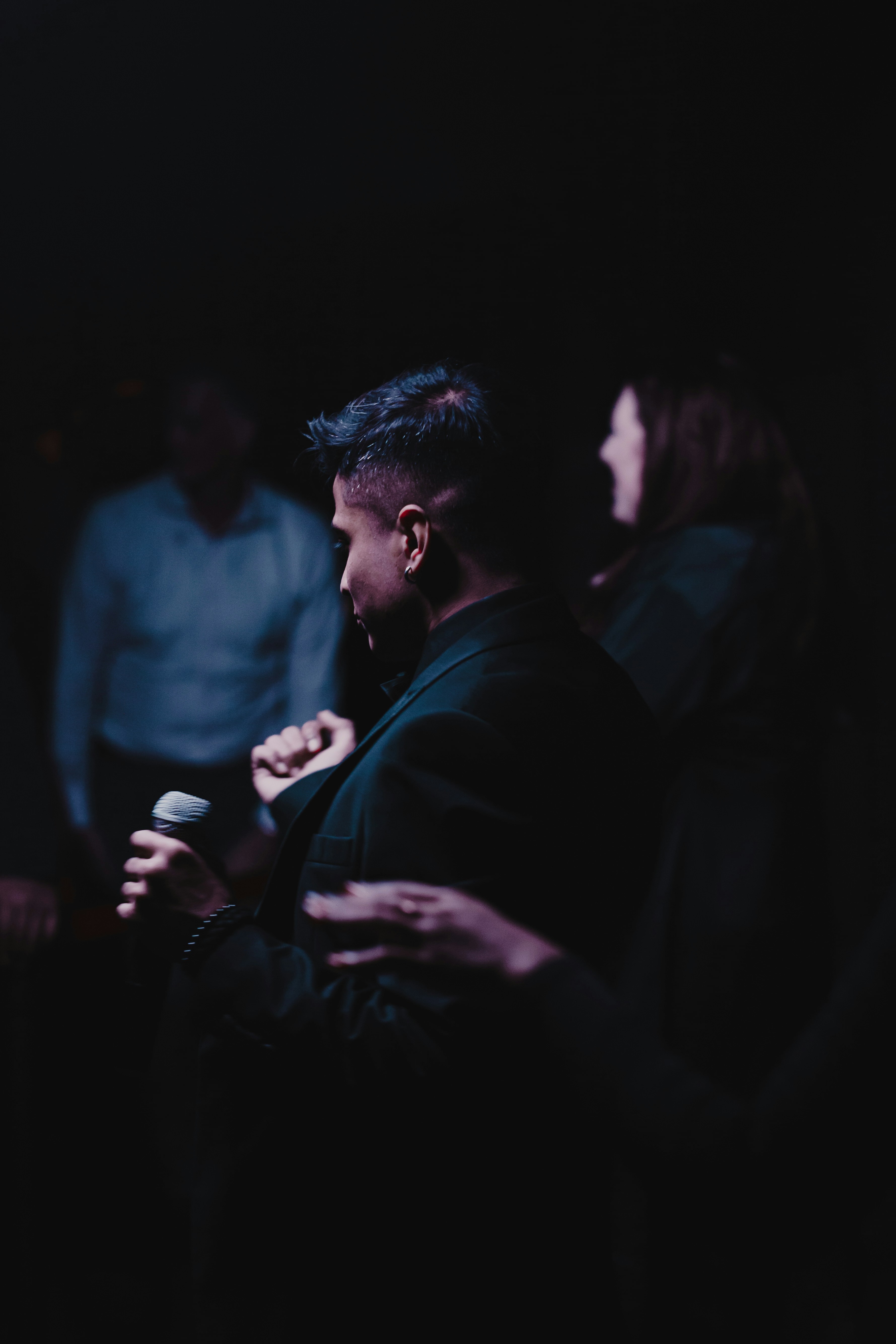 Une femme tenant un micro dans une pièce sombre