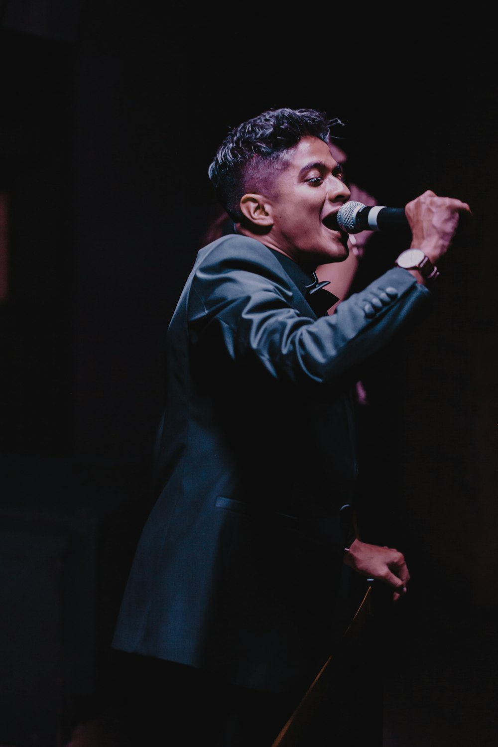 a man in a suit singing into a microphone