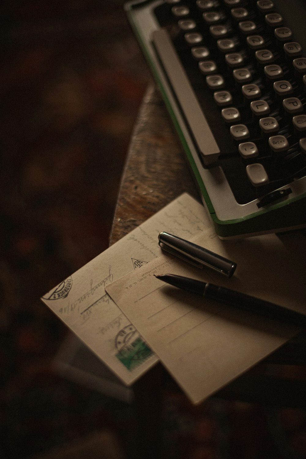 a desk with a keyboard and a pen on it