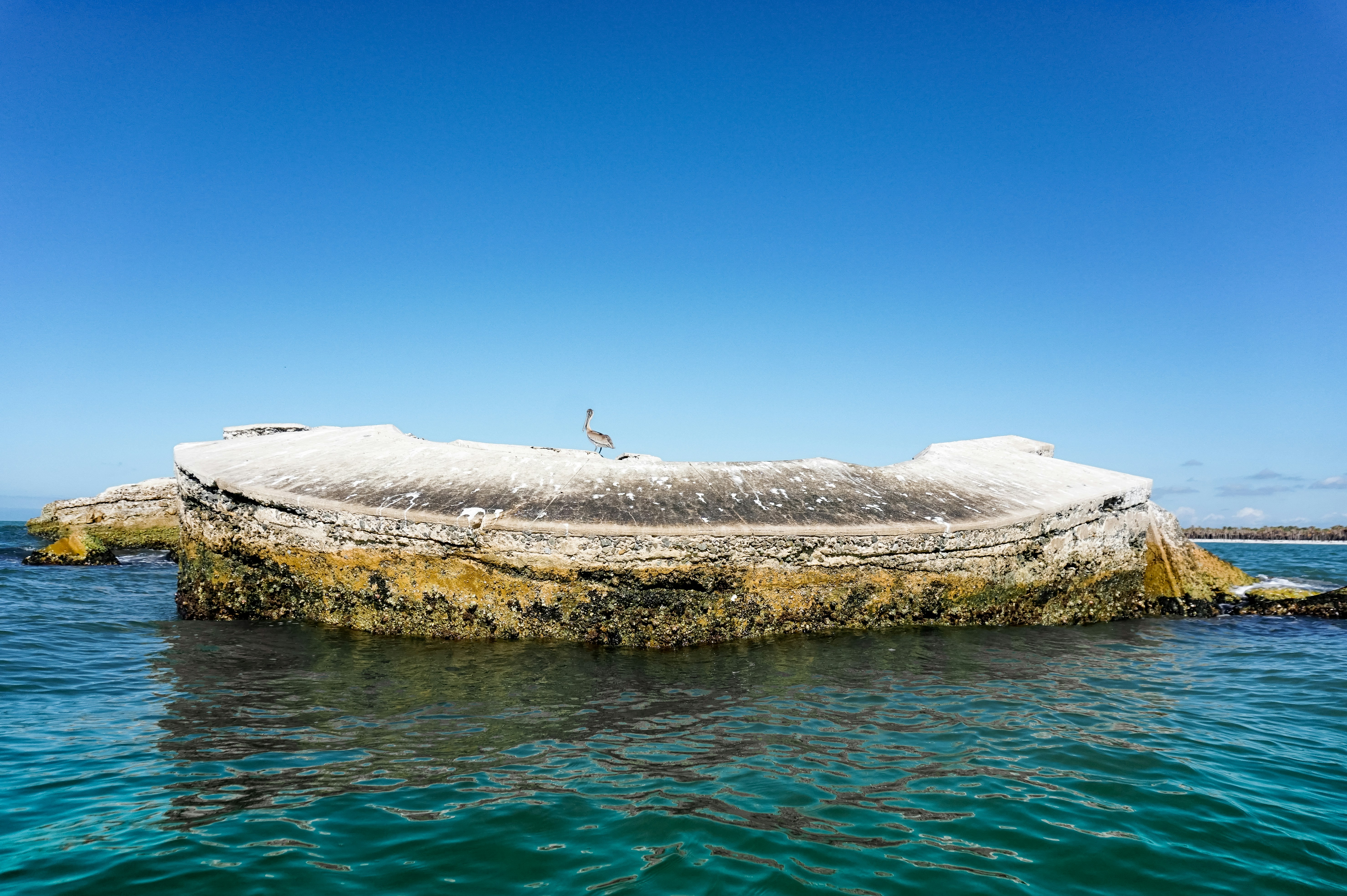 Un bateau assis au sommet d’un rocher dans l’océan
