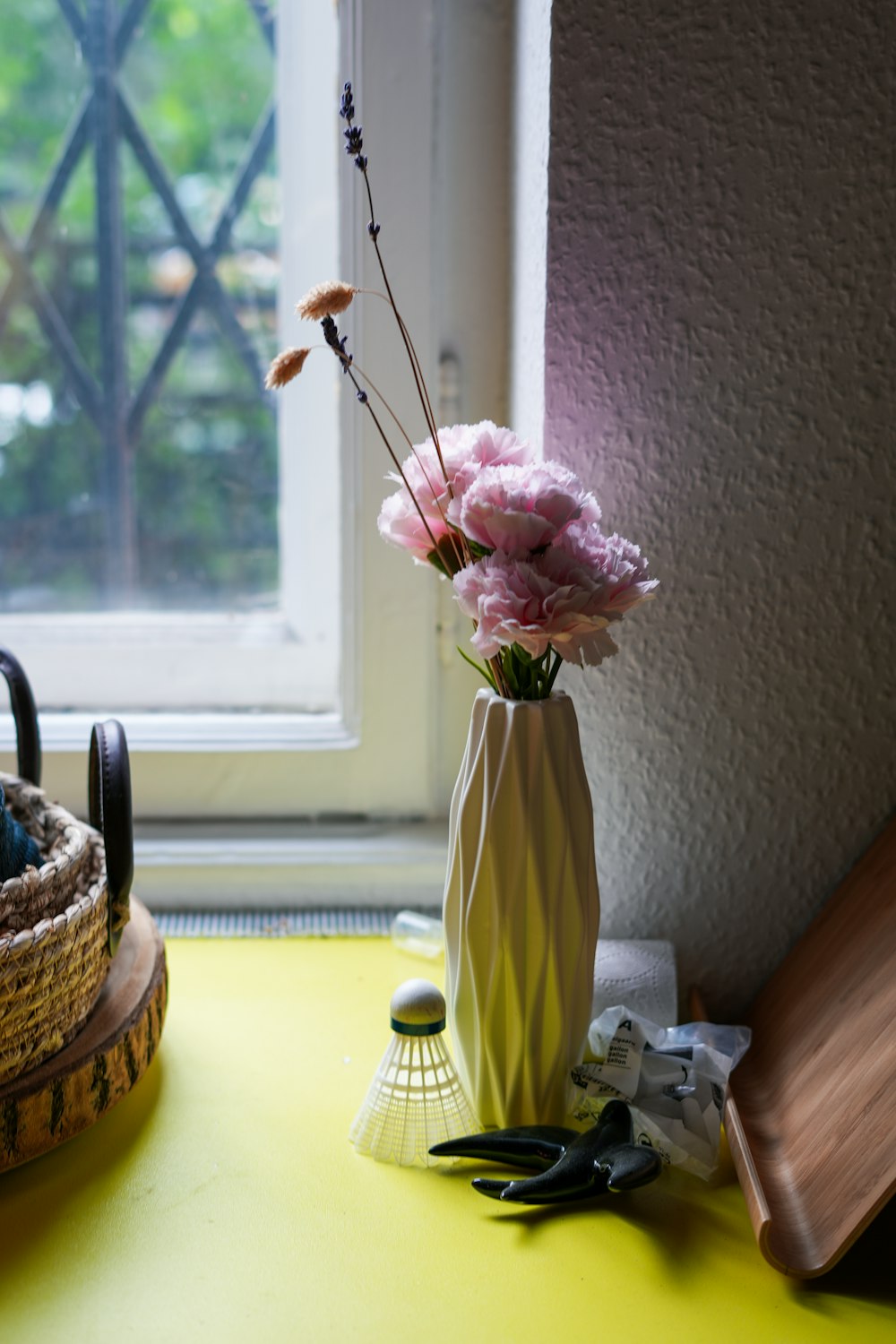 a vase of flowers on a table near a window