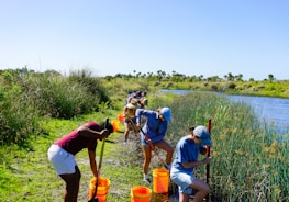 A small group working together to purify water using improvised tools outdoors.