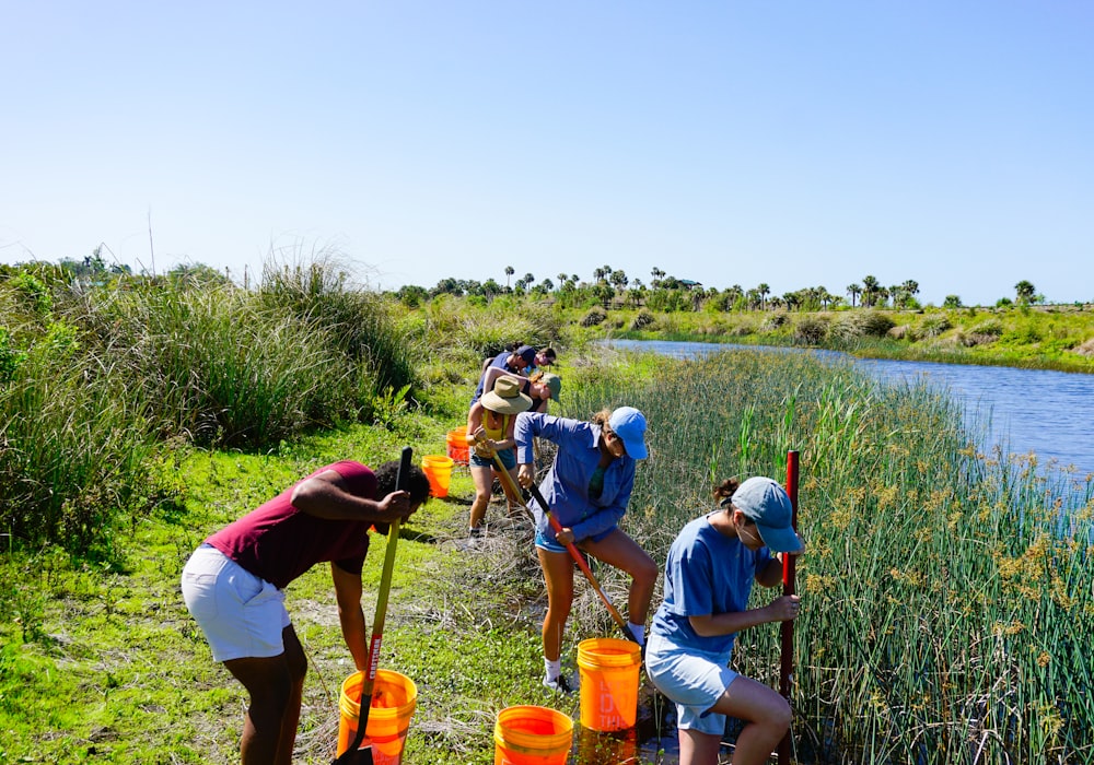 a group of people standing next to a river