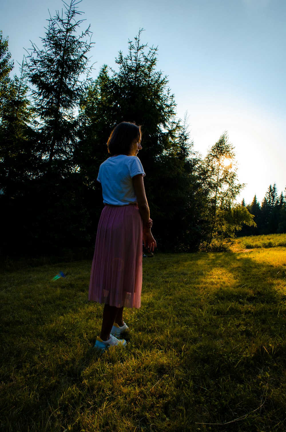 a little girl standing in a field with a frisbee