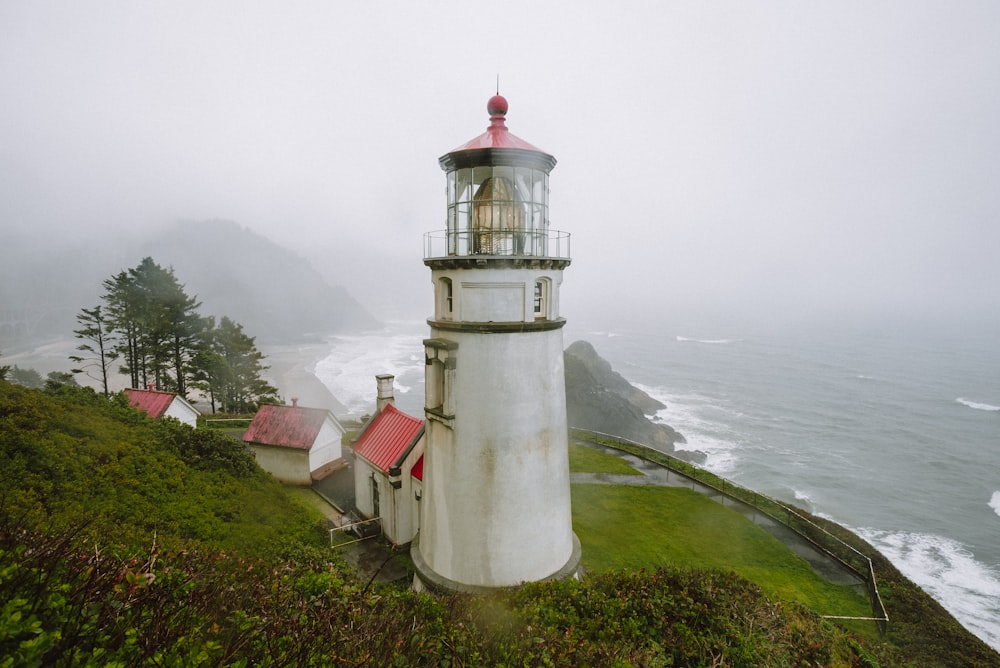 a light house sitting on top of a lush green hillside