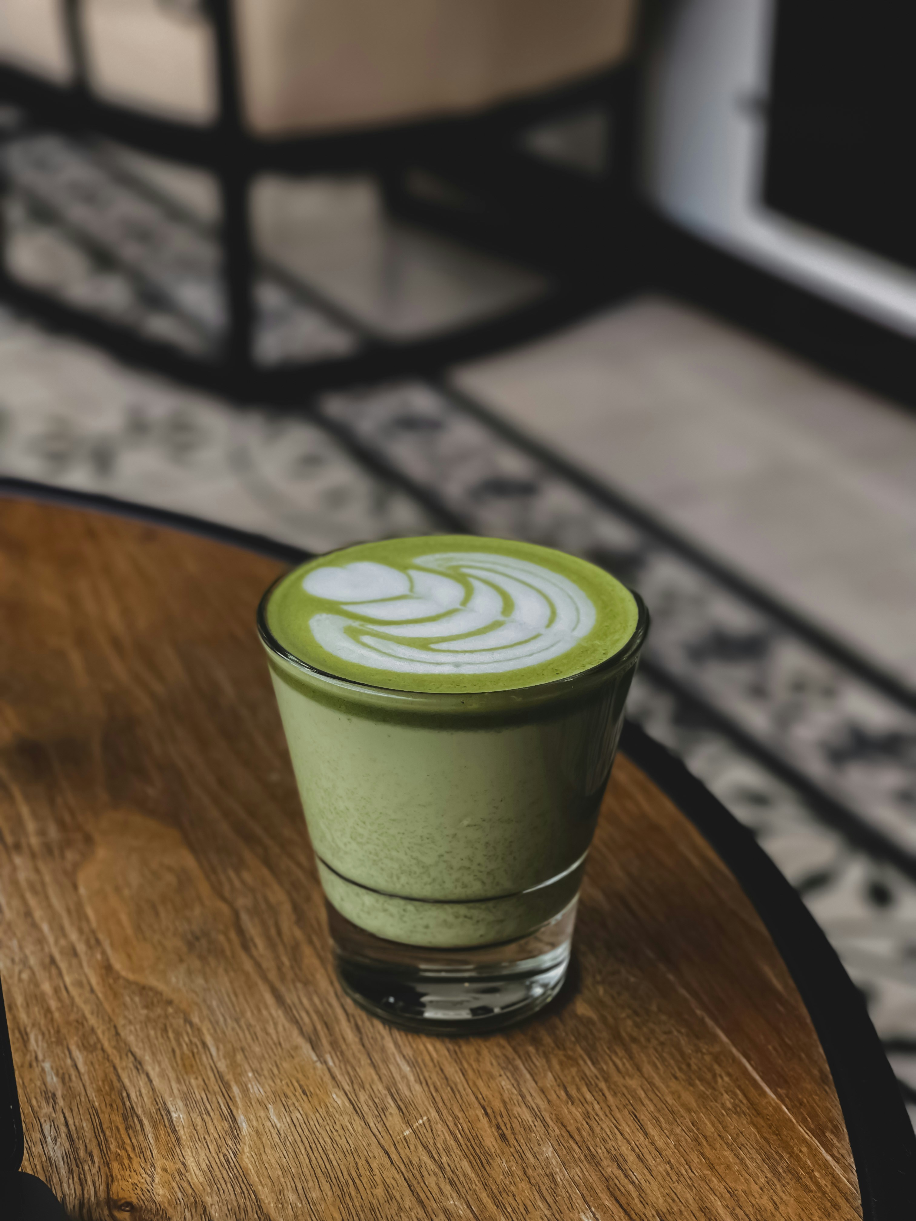 a green drink sitting on top of a wooden table