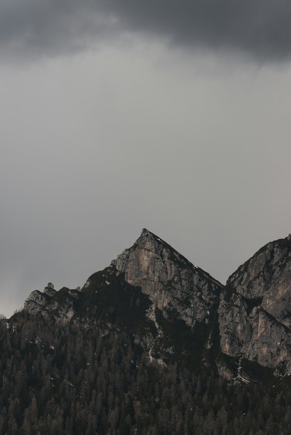 Un avión volando sobre una cadena montañosa bajo un cielo nublado