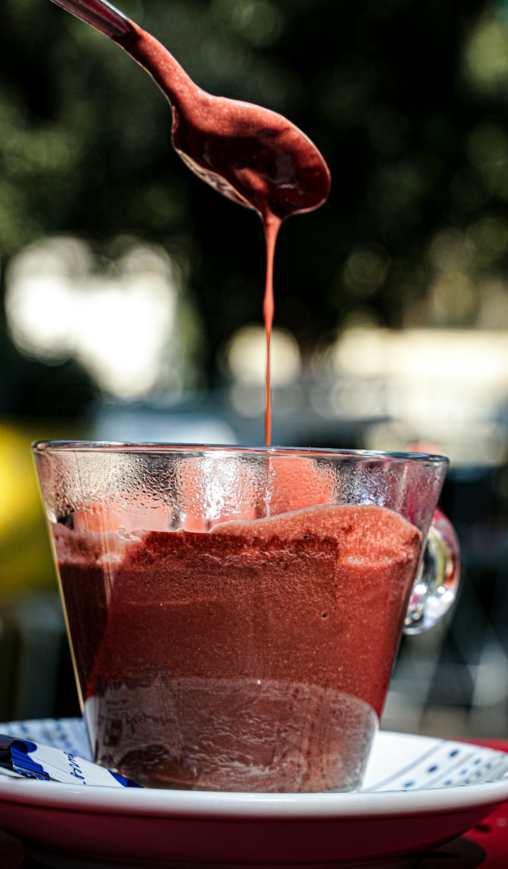 a spoon pouring red liquid into a bowl