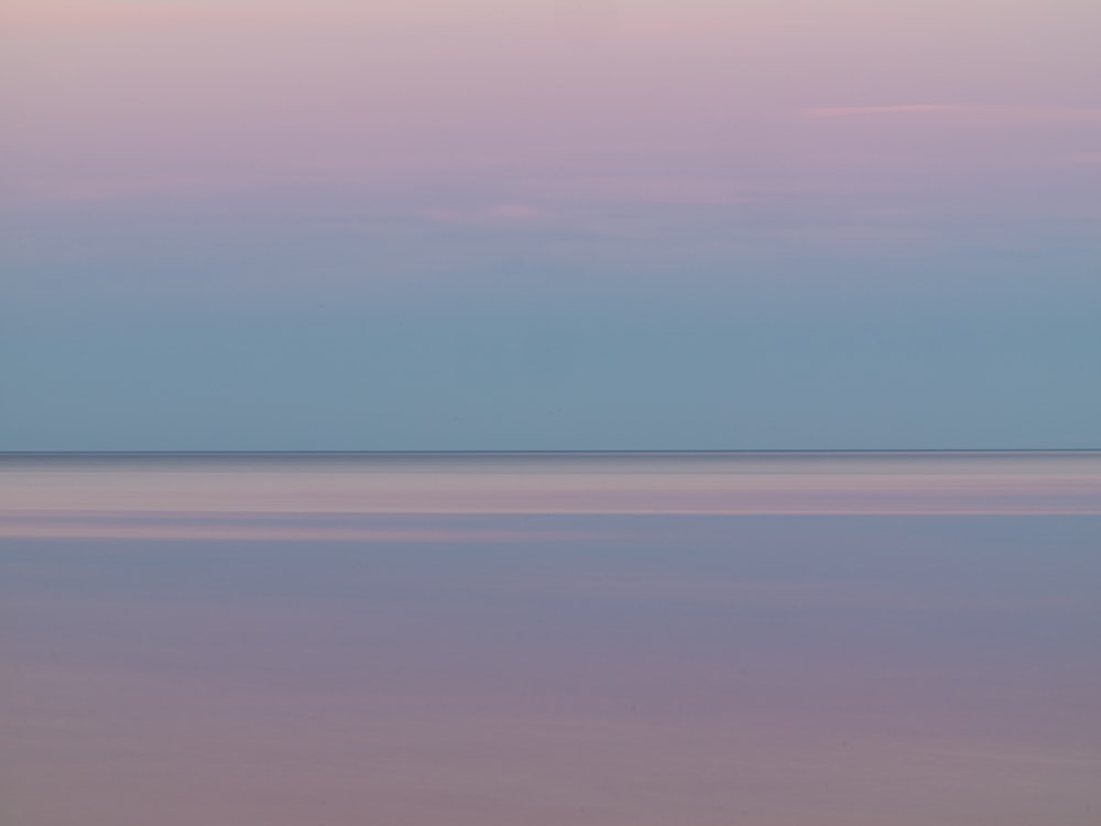 a large body of water sitting under a purple sky